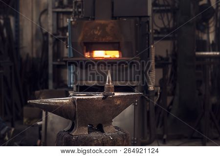 Mallet And Tongs On An Anvil In Front Of A Furnace