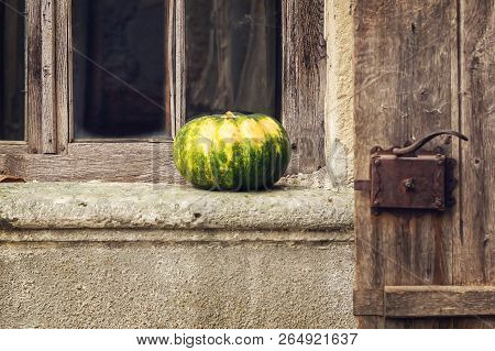Beautiful Pumpkin On The Windowsill On The Background Of The Old Window.