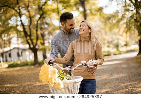 Active Senior Couple Together Enjoying Romantic Walk With Bicycle In Golden Autumn Park