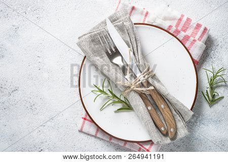 White Plate And Cutlery On Stone Table Top View. Table Setting.
