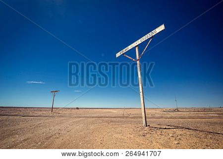 Australia â Old Ghan railway crossing at the outback desert under blue sky 