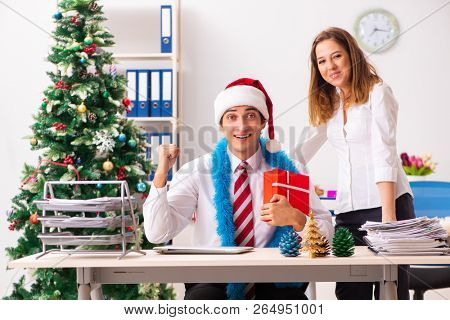 Colleagues exchaing christmas presents in office