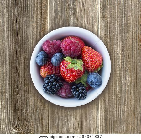 Top View. Fruits And Berries In Bowl On Wooden Background. Ripe Raspberries, Strawberries, Blackberr