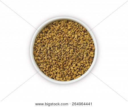 Fenugreek Seeds In A Wooden Bowl Isolated On White. Fenugreek Seeds Isolated On White Background. To