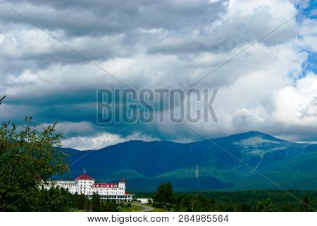 Sun Breaks Through Summer Rain Clouds Above Mount Washington And Hotel. Mount Washington Is The Tall
