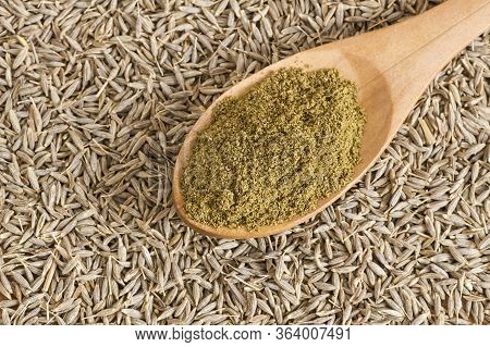 Pile Of Dry Caraway Spice With Ground Caraway Powder In Wooden Spoon. Healthy Food Cumin Spice Conce