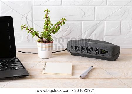 Black Air Ionizer Near Laptop On A White Wooden Table. Air Purifier With Anion Generator For Fresh A
