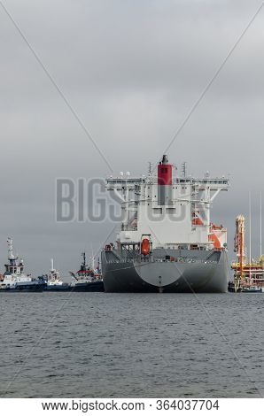 Lng Terminal And Gas Tanker - A Large Ship Maneuvers Into The Unloading Quay