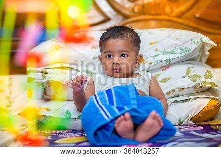A Asian Baby Boy Is Looking And Playing At Colorful Toys.