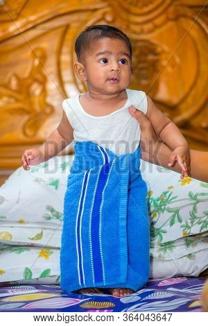 A Asian Baby Boy Is Looking And Playing At Colorful Toys.