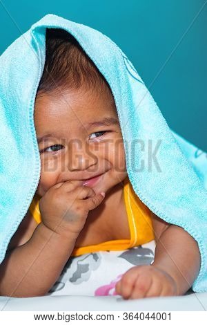 A Six Months Age Asian Baby Boy Playing A Yellow Taddy Bear.