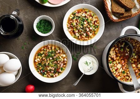 Summer Cold Okroshka Soup With Sausage, Vegetables And Kvass Over Brown Stone Background. Traditiona