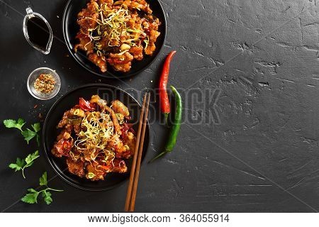 Spicy Garlic Fried Chicken (kkanpunggi). Asian Chicken In Sweet And Sour Sauce On Plate Over Black S