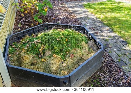 Making compost in composting bin in small garden