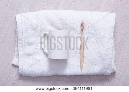 Styled Bathroom Counter With Soft Towel, Cup And Toothbrush. White Towel On Light Background, White 