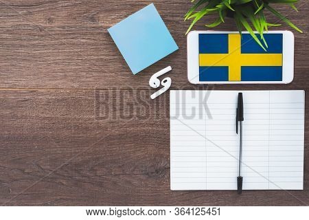 Sweden Flag Smartphone, Wireless Headphones, Notepad, Green Plant On Brown Desktop, Place For Text