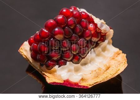 Big Ripe Red Granets Or Garnets Close Up On Glossy Black Backgground.