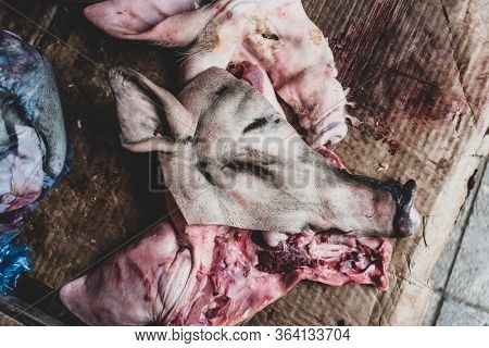 Pig's head butchered ready to sale at the Bac Ha Market. backgound blurry and unrecognizable person