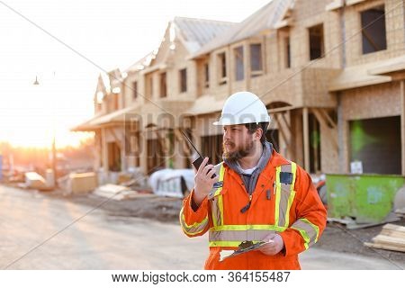 Foreman Talking By Walkie Talkie On Construction Site.