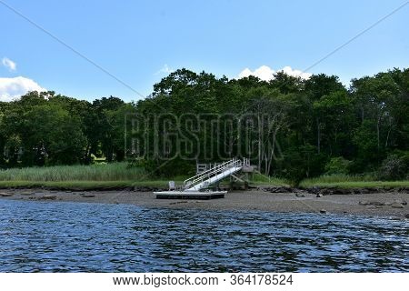 Dock Resting On A Mud Flat Along A Beautiful Tidal River.