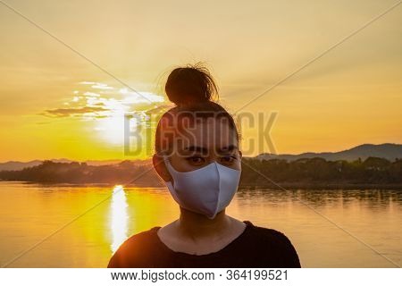 Close Up Young Asia Woman Putting On A Fack Mask To Protect From Airborne Respiratory Diseases As Th