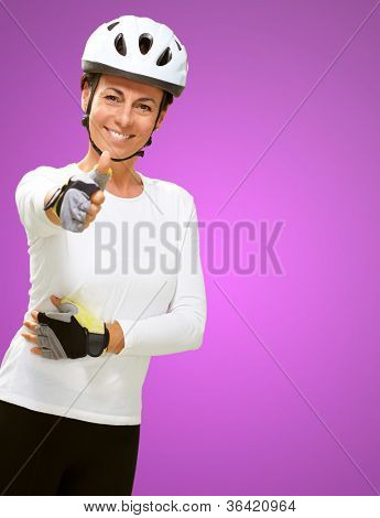 Femme portant casque montrant le pouce en haut isolé sur fond rose