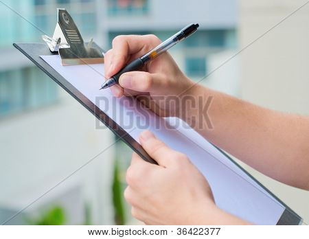 Uomo d'affari tenendo un appunti e scrittura, fuori porta