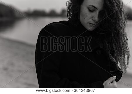 Curly Woman In The Coat Looking Down