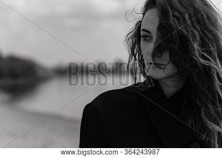 Curly Woman Wearing The Coat And Looking To The Side
