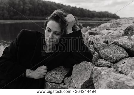 Woman Lying On The Stones Near The River And Looking Down