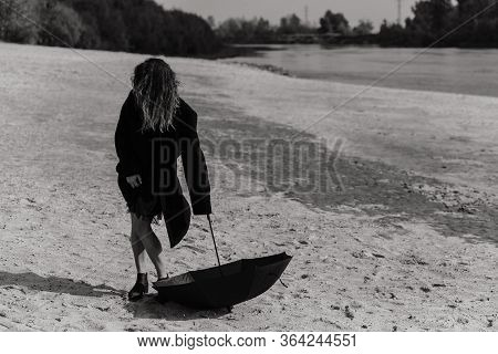 Woman In The Coat Holding Umbrella Down