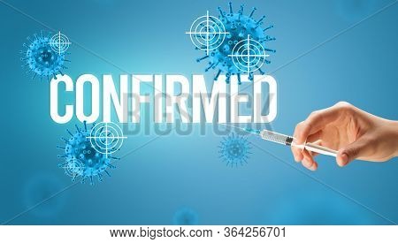 Close-up view of doctor's hand in a white glove holding syringe with CONFIRMED inscription, coronavirus antidote concept