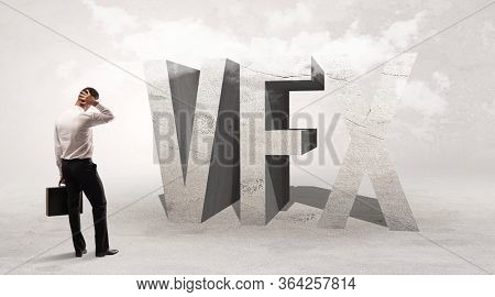 Rear view of a businessman standing in front of VFX abbreviation, attention making concept