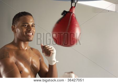 Young African American athlete working out on a speed bag in a gym