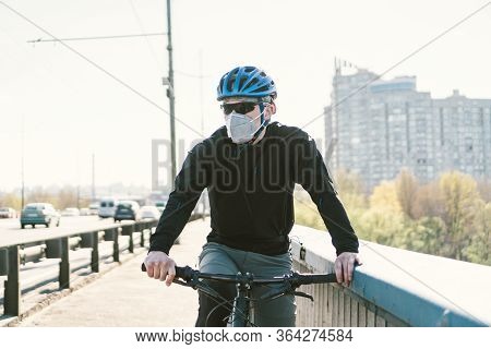 Male Cyclist On Mountain Bike In Protective Mask Respirator In Polluted City. Guy Ride To Work On En