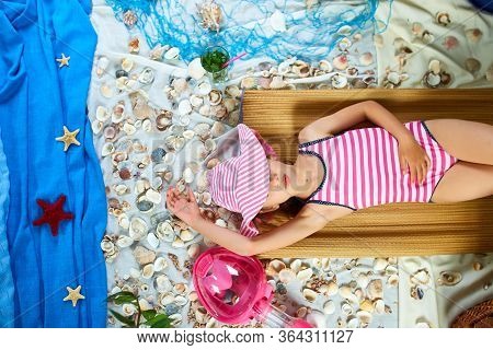 The Girls Is Lying On A Fictional Beach Near The Sea Or Ocean, Sunbathes.