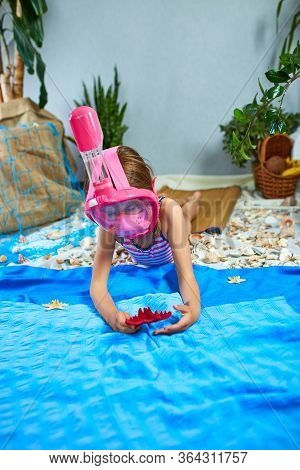 Little Girl Wearing Snorkeling Mask Imitates Swimming In Fictional Beach