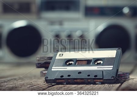 Compact Cassette Tape On The Foreground With A Cassette Recorder On The Background
