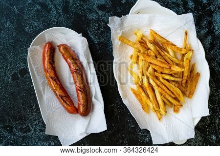 Homemade Sausage With Skinny French Fries Potatoes In Plate And Paper Towel Also Called Peruvian Sal