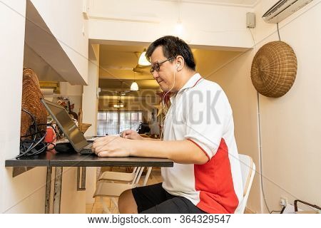 Matured Asian Business Man Work From Home Listening To Video Conference Presentation Call With Colle