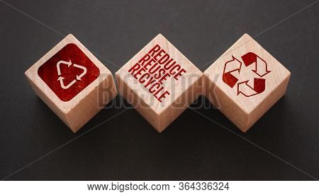 Reduce, Reuse And Recycle Word Written On Wooden Blocks On Black. Save The Planet Ecological Concept