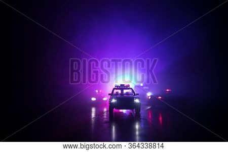 Police Cars At Night. Police Car Chasing A Car At Night With Fog Background. 911 Emergency Response