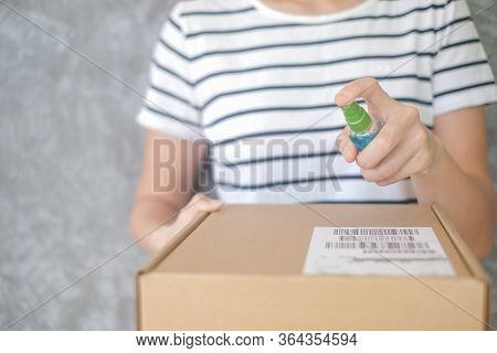 Asian Woman Wears Mask Using Spray Alcohol Sanitizer Cleaning Parcel Post, To Prevent The Virus And