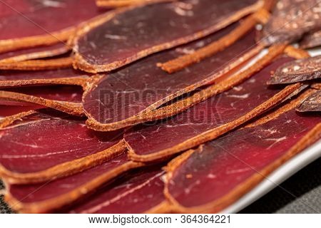 Basturma On A White Plate. Armenian Food. Sun-dried Basturma. Ready Snacks. Beef Jerky. Shallow Dept