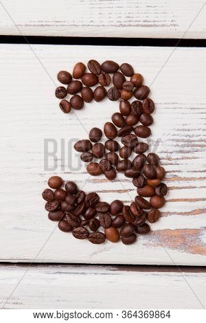Coffee Beans In The Form Of A Number 3. Brown Roasted Seeds Arranged In A Three Shape On White Woode