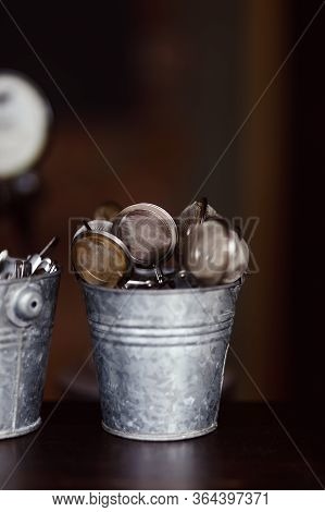 Tea Strainers In A Zinc Bucket On A Bar Counter