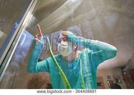 Woman With Medical Mask On Their Faces Looking Through Window, Stay At Home, Selfisolation To Preven