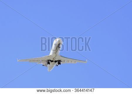 Under View Of A Passenger Aeroplane Coming Into Land With Landing Gear Down And Dropping In Altitude