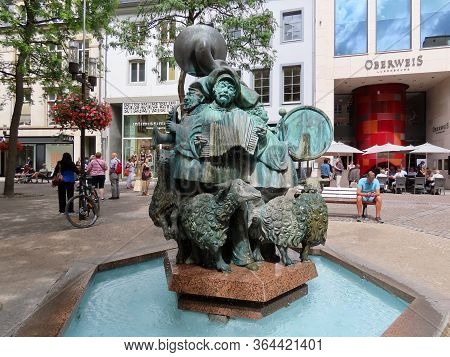 Luxembourg, Luxembourg - August 8, 2019. Green Copper Sculpture With Dancing Musicians And Happy She