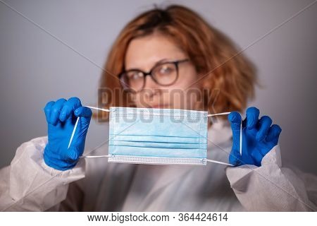Covid-19. 2019 Novel Coronavirus (2019-ncov) Concept. Young Red-haired Girl Doctor In A White Protec